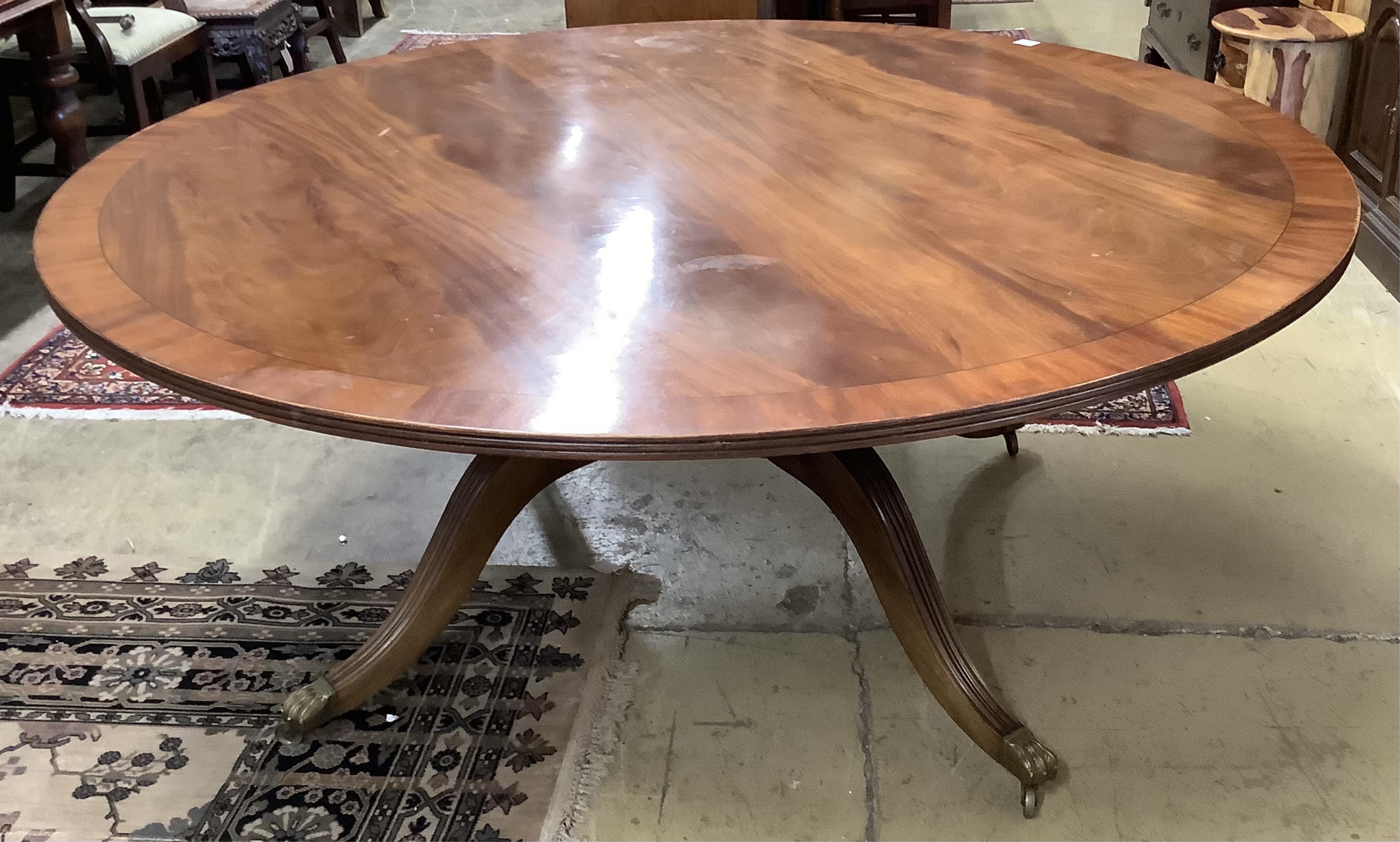 A reproduction George III style circular mahogany dining table, diameter 183cm, height 74cm
